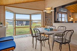 een keuken en eetkamer met een tafel en stoelen bij 1069-Thisted-Kobbelsti-23 in Klitmøller +10 foto's