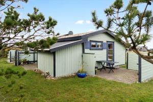 een kleine witte schuur met een picknicktafel in een tuin bij 1069-Thisted-Kobbelsti-23 in Klitmøller