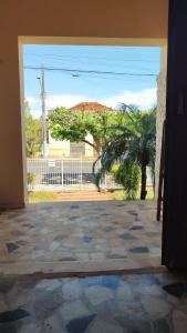 een open deur naar een patio met een palmboom bij POUSADA ELSHADAY Centro in Osvaldo Cruz