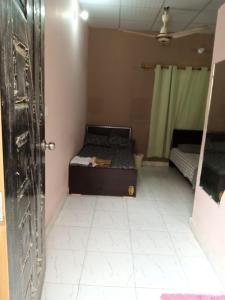 una habitación vacía con una cama y una puerta en Johar hostel, en Karachi