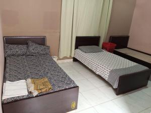 Dos camas en una habitación pequeña con 3 estrellas que dice que es lo que dice en Johar hostel, en Karachi