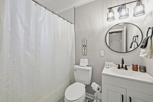 ein Badezimmer mit Toilette, Waschbecken und Spiegel in der Unterkunft Peace at the Creek in Goose Creek + 17 Fotos