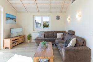 ダゲビュルにあるNordseeperleのソファとテレビのあるリビングルーム