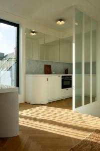 a kitchen with white cabinets and a large window at Hotel Montaigne in Ostend