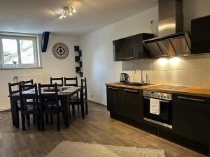 a kitchen with a table and a dining room at Apartment London in Bergen an der Dumme