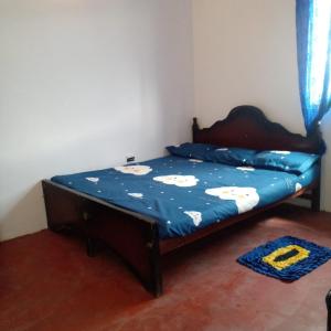 ein Schlafzimmer mit einem Bett mit blauer Decke in der Unterkunft Nuwara eliya rashini mountain view cottage in Nuwara Eliya