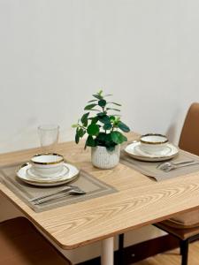 a wooden table with plates and a potted plant on it at Rafaels Staycation at Arezzo in Davao City
