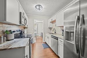 eine Küche mit weißen Schränken und Geräten aus Edelstahl in der Unterkunft Peace at the Creek in Goose Creek