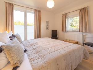 a bedroom with a large bed and a large window at Sagard - Ferienhaus Rubin in Sagard