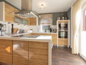 a kitchen with wooden cabinets and a large sink at Sagard - Ferienhaus Rubin in Sagard