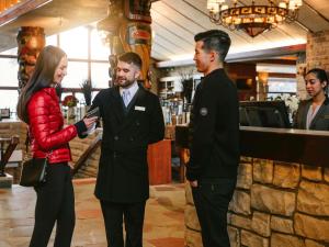 a woman standing next to two men in a bar at Fairmont Jasper Park Lodge in Jasper