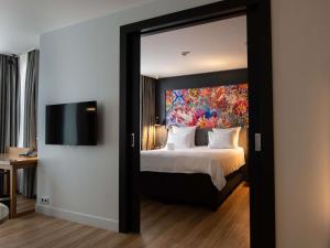 a bedroom with a large bed with a large mirror at Swissôtel Amsterdam in Amsterdam
