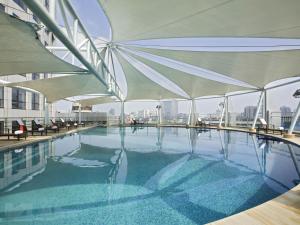 a swimming pool with umbrellas on top of a building at Swissotel Foshan, Guangdong - Free shuttle to Canton Fair in Foshan