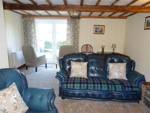 Una sala de estar con un sofá azul y sillas. en Glan Wye, en Rhayader 41 fotos más
