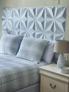 西区West end inn的一张带蓝色棉被的床和一张带台灯的桌子