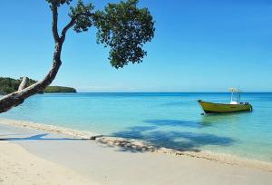a boat sitting in the water on a beach at les jardins de sainte Anne in Sainte-Anne