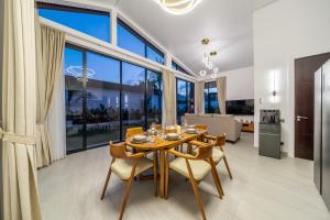 a dining room with a table and chairs and a large window at Bali Bliss - New 2BR Villa with Private Pool & Green Garden Views in Ungasan