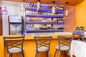 Una barra con tres taburetes en un restaurante. en M3 Stella Hotel, en Kampala