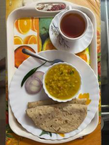 a tray with a plate of food and a cup of coffee at Mitali Homestay in Dibrugarh +7 photos