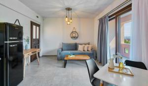 a living room with a blue couch and a table at Villa Melia Luxury Suites in Ierissos