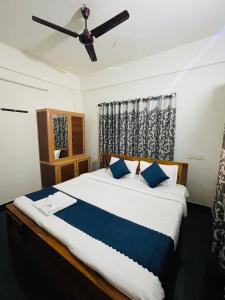 ビサーリーにあるVythiri saara innの天井ファン付きの大きなベッドのある寝室