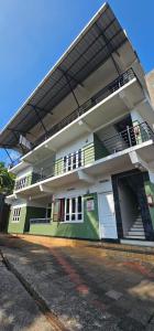 ビサーリーにあるVythiri saara innのバルコニーのある白と緑の建物