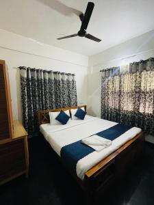 ビサーリーにあるVythiri saara innのベッドルーム1室(ベッド1台、シーリングファン付)