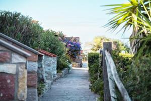 een stenen pad met een hek en bloemen bij Welcome to Portoscuso in Portoscuso