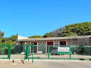een gebouw met een bord voor een hek bij Welcome to Portoscuso in Portoscuso