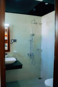 a bathroom with a shower and a sink at Kings Town Hotel Anuradhapura in Nikawatawana