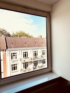 een raam met uitzicht op een gebouw bij Luxury in Eimsbüttel in Hamburg