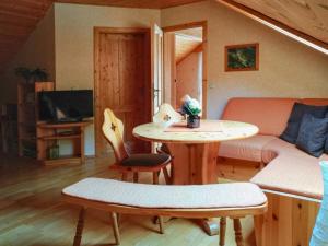 a living room with a table and a couch at Gläserberg in Langenbach