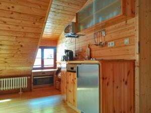 a kitchen with wooden walls and a stainless steel refrigerator at Gläserberg in Langenbach