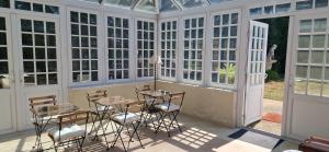a room with a table and chairs in a conservatory at Suite Majorelle du Château in Gaillan-en-Médoc