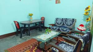 a living room with a table and chairs and a blue wall at Mitali Homestay in Dibrugarh