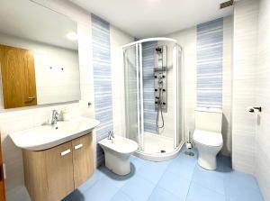 a bathroom with a sink and a toilet and a shower at Alice House in Miño