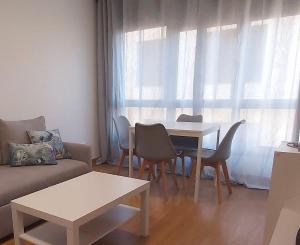 a living room with a table and chairs and a couch at Alice House in Miño