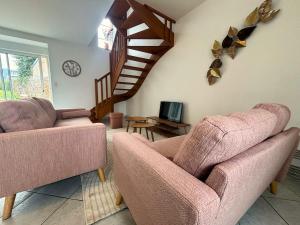 a living room with two chairs and a staircase at Maison Centre Ville - Saint-James in Saint-James