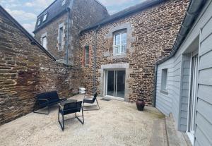 a patio with two chairs and a brick building at Maison Centre Ville - Saint-James in Saint-James