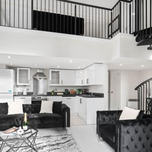 ein Wohnzimmer mit zwei schwarzen Sofas und einer Küche in der Unterkunft Stylish Penthouse - 2 King Size Beds - Parking - Private Terrace 1401M in Birmingham + 40 Fotos
