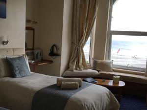 a hotel room with a bed and a window at Cubbon House in Douglas