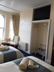 a hotel room with two beds and a mirror at Cubbon House in Douglas