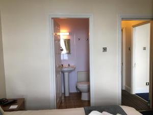 a bathroom with a toilet and a sink at Cubbon House in Douglas