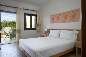 a bedroom with a white bed and a balcony at Cormoran Residence in Villasimius +64 photos