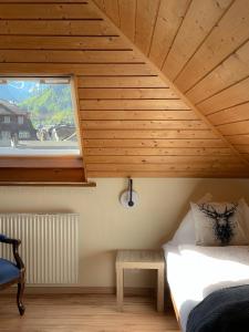 a room with a bed and a window and a table at Hotel Harder Minerva in Interlaken
