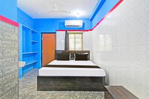 a bedroom with a bed in a blue room at Hotel O New Cuttack Guest House in Cuttack