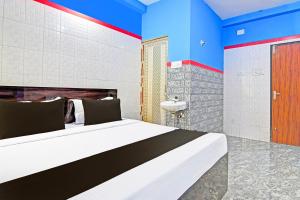 a bedroom with a large bed with blue and red walls at Hotel O New Cuttack Guest House in Cuttack +20 photos
