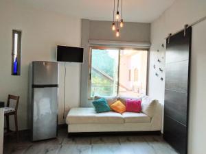 een woonkamer met een bank met kleurrijke kussens erop bij Casa Arbol de Paz in Chacala