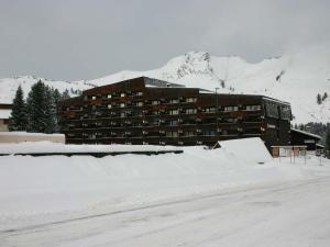 ein Gebäude im Schnee vor einem Berg in der Unterkunft Appartement cosy au Praz de Lys pour 6 pers, près des pistes, 2 pièces - FR-1-815-20 in Le Praz de Lys