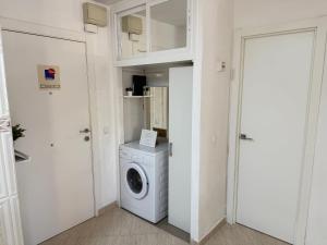 een witte wasruimte met een wasmachine bij Apartments Benalmadena in Benalmádena